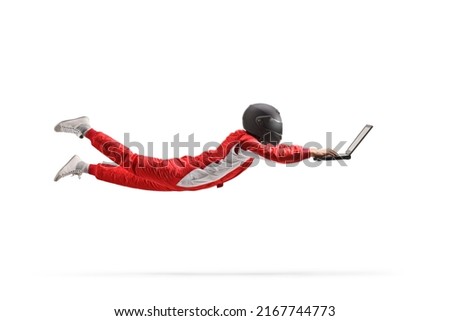 Motorsport racer with a helmet flying and working on a laptop computer isolated on white background Royalty-Free Stock Photo #2167744773