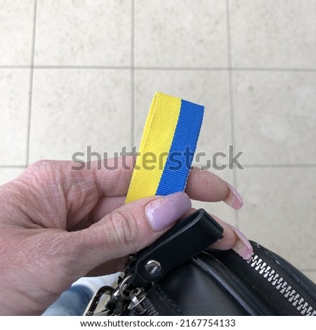 Macro photo Ukrainian patriotic ribbon. Stock photo Ukraine flag in hand