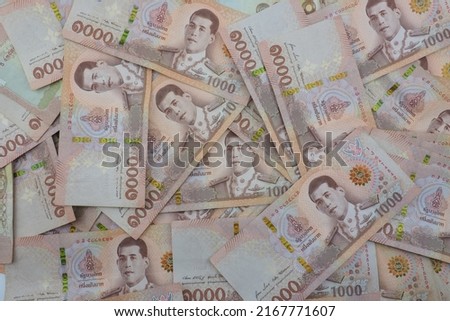 Close-up a pile of one thousand Thai Baht (THB) banknotes of Thailand. Cash of thousand baht bills, Background image with high resolution. Royalty-Free Stock Photo #2167771607