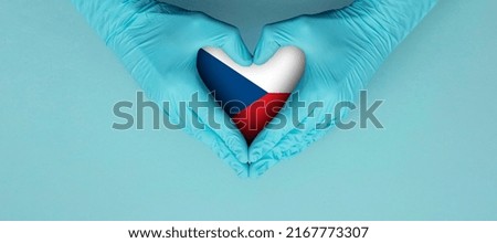 Doctors hands wearing blue surgical gloves making hear shape symbol with czech republic flag