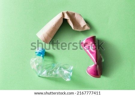 recycling concept - recycling symbol made of plastic bottle, toilet paper roll and can Royalty-Free Stock Photo #2167777411