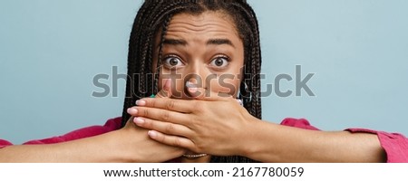 Young black shocked woman with pigtails covering her mouth isolated over blue background