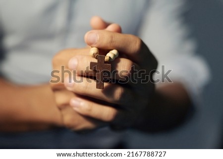 Speaking to a higher power. Cropped shot of a mans hands holding a rosary. Royalty-Free Stock Photo #2167788727