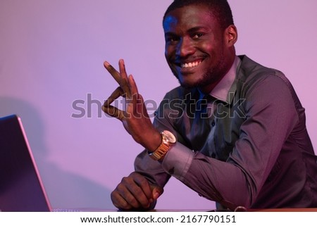 african man using his laptop smiling and does okay gesture