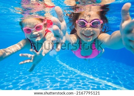 little girls swimming  in pool  underwater.