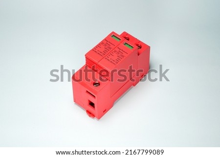 Surge Protective Device (SPD) is a tool to protect electrical installations from lightning strikes. Red DC surge arrester breaker on white background isolated. Royalty-Free Stock Photo #2167799089