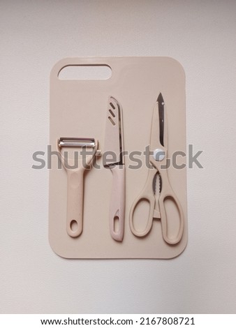 a set of kitchenware.  There are knives, peeler, scissors and cutting boards.  isolated background in white. copy space. much space for text or quote