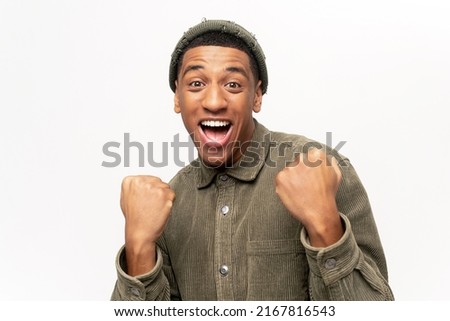 Excited overjoyed man shouting making yes gesture, amazed with his victory, triumph. Indoor studio shot isolated on white background Royalty-Free Stock Photo #2167816543