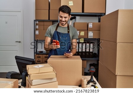 Young hispanic man business worker using smartphone and credit card at storehouse Royalty-Free Stock Photo #2167823819