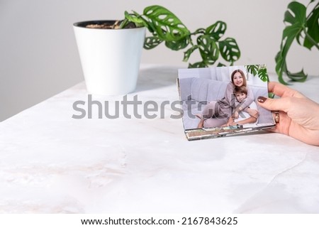 woman sitting at desk and looking at printed photos, remember nostalgia for a day of rest. photography cards, background. Mock up.