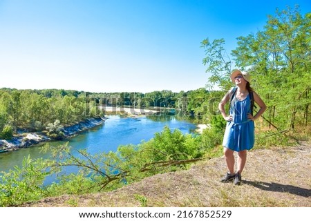 Beautiful woman smiles in a wonderful summer afternoon at italian natural reserve "parco del Ticino". Portrait of young girl in Casottole, Lombardy with landscape and Ticino river in background. 
