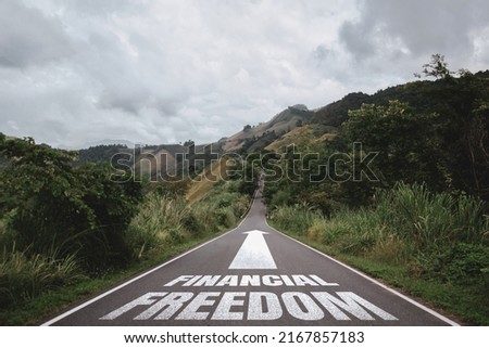 Financial freedom written on the road in the middle of asphalt road. Concept of planning and challenge or career path, business plan, strategy ,opportunity and change my life. Royalty-Free Stock Photo #2167857183