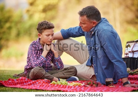 His dad is always there for him. Shot of a father comforting his young son while sitting in a park. Royalty-Free Stock Photo #2167864643