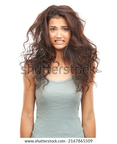 Need a hairdresser. A beautiful woman looking at the camera looking perturbed by her damaged hair. Royalty-Free Stock Photo #2167865509
