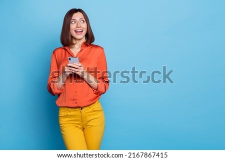 Portrait of attractive cheerful curious girl using device copy space media news like isolated over bright blue color background Royalty-Free Stock Photo #2167867415