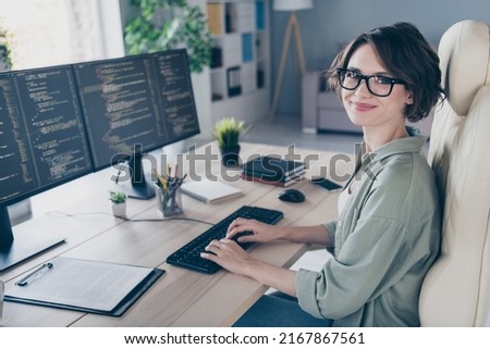 Photo of charming positive hacker female remote working monitoring debugging security problems indoors in workplace