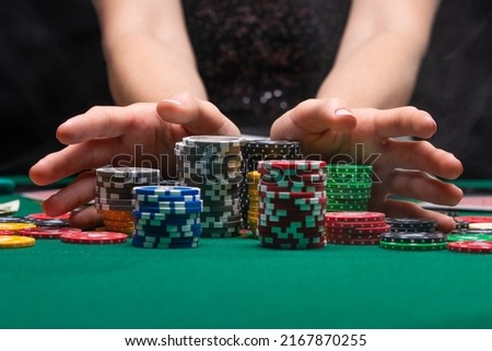 A player playing in a casino raises bets with chips. Gaming business Royalty-Free Stock Photo #2167870255