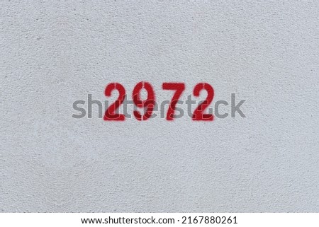 Red Number 2972 on the white wall. Spray paint.
