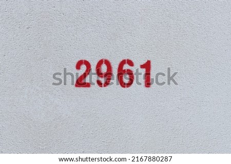 Red Number 2961 on the white wall. Spray paint.
