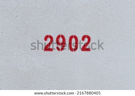 Red Number 2902 on the white wall. Spray paint.
