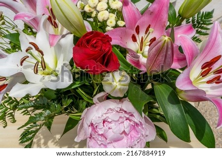 Close up of colorful bouquet - pink peonies, purple and white lily flowers, red roses. High quality photo