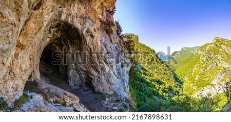 Entrance to a cave in the mountain. Mountain cave entrance Royalty-Free Stock Photo #2167898631