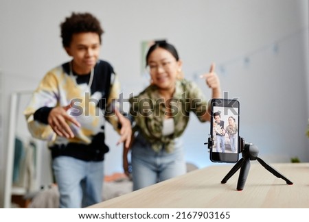 Background image of two gen Z teenagers filming video for social media, focus on smartphone screen, copy space