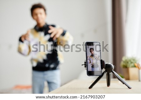Background image of Gen Z teenager filming video for social media at home, focus on smartphone screen, copy space