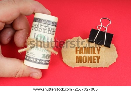 Business concept. The man has dollars in his hands, on a red surface there is a cardboard sign with the inscription - FAMILY MONEY