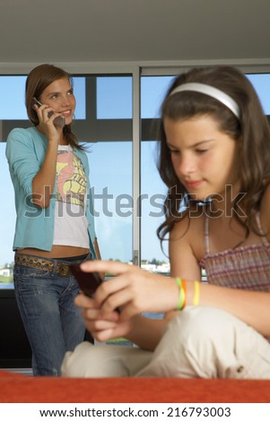 Sisters using their cell phones.