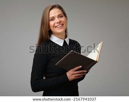 Happy woman teacher or student in black business suit holding book, isolated female portrait.