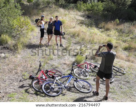 Young man taking a picture of two young women and a young man