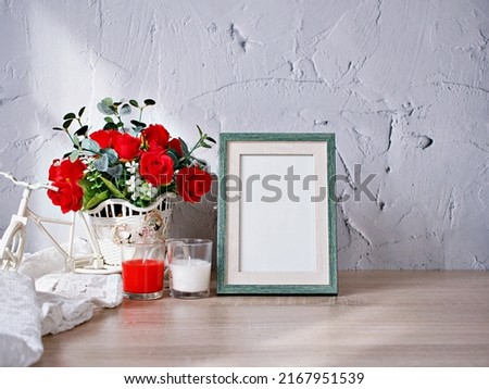 Empty photo frame candles artificial red rose on bike toy on wood table, cement texture background, gray color ,copy space for lettering ,Valentine's day ,love concept ,celebrate classic elegant card