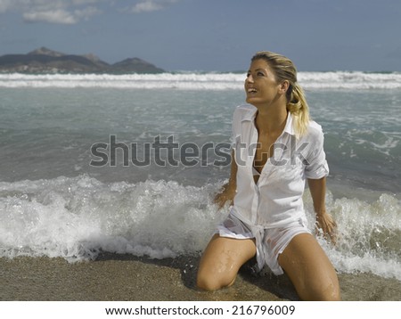 Mid adult woman kneeling on the beach