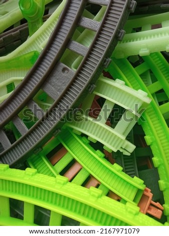 pile of green gray and brown railroad toys. railroad tracks for toy train running.
