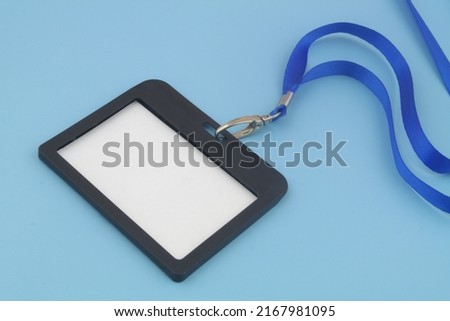 Blank black badge with blue ribbon on blue background