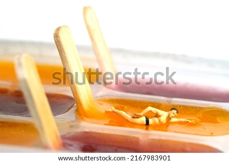 Miniature people toy figure photography. Creative summer pool vacation concept. A man doing free style swimming on pudding jelly ice cream stick. Image photo