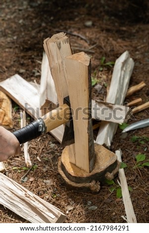  	Outdoors, campgrounds. Preparing firewood for a bonfire