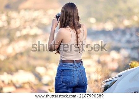 I just love the beautiful sights. Shot of a young woman using her camera while spending time outdoors.
