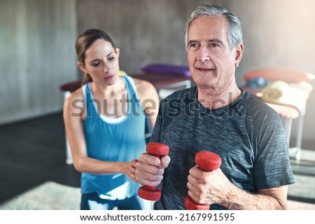 Maintaining muscle mass with regular exercise. Shot of a senior man working out with his physiotherapist. Royalty-Free Stock Photo #2167991595
