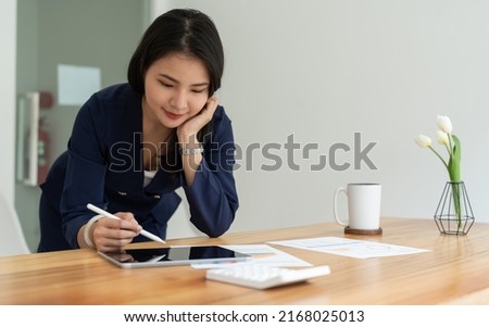 Close up hand of businesswoman using stylus pen signing contract on digital tablet on office table. Business manager proofing e-document, electronic signature, e-signing mobile app