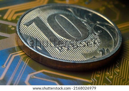 A coin with a face value of 10 rubles lies on a microcircuit. close-up. Translation of the inscription on the coin: "10 rubles" The concept of the digital economy in the Russian Federation