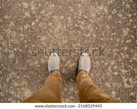 Feet on the asphalt road in the city.