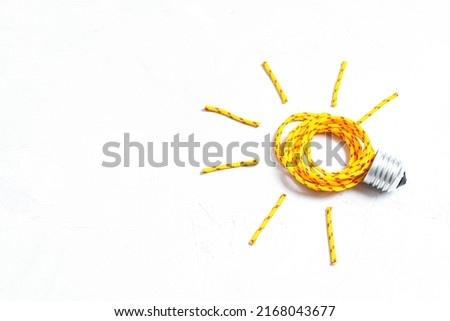 Glowing lightbulb symbol made from a clothes drying rope and a bulb base isolated on white background. Managing household chores creatively.