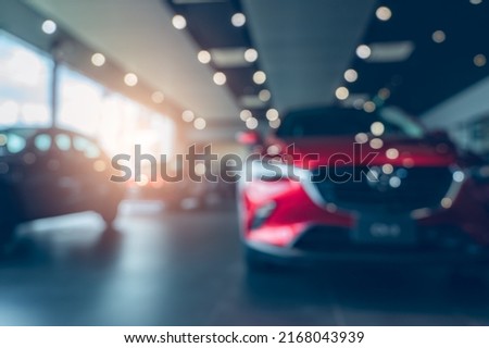 Blurred photo new red car parked in showroom. Car dealership office. Car parked in showroom with care. Car for sale and rent business. Automobile leasing market. Electric vehicle. Automotive industry. Royalty-Free Stock Photo #2168043939