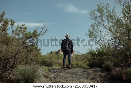 Adult man in cowboy hat in oasis of desert. Almeria, Spain