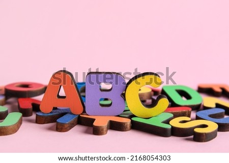 Colorful letters on pink background. Alphabet concept