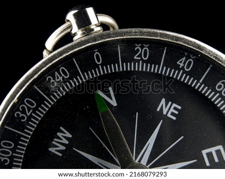 Selective focus.Close-up silver compass on a black background