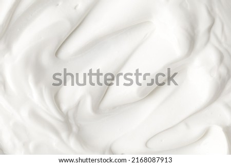 Texture of white cream. Mousse texture. Yogurt ice cream background. Tasty liquid texture of sour cream. Creamy dairy product background. Yogurt waves of white mousse.  Cream. Close up, macro