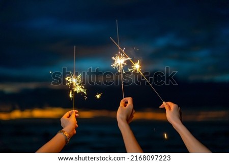 Group of Happy young Asian woman sitting and playing sparklers together on tropical island beach at summer night. Smiling female friends enjoy and fun outdoor lifestyle on holiday travel vacation trip Royalty-Free Stock Photo #2168097223